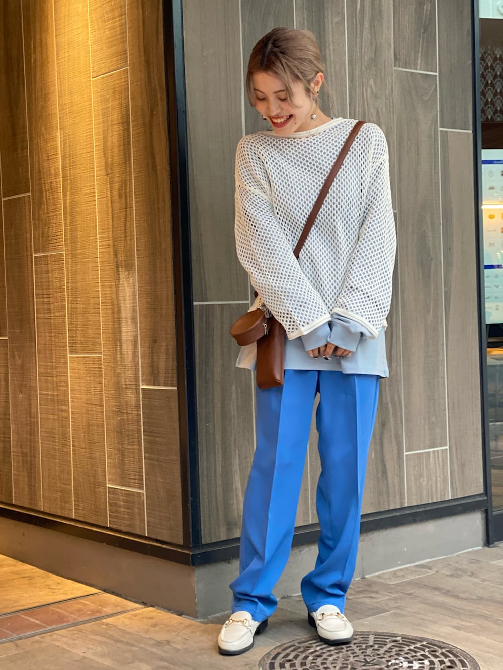 ホワイト系のニット/セーター、ブルー系のTシャツ/カットソー、ブルー系のスラックスを着用したレディースの冬コーディネートの2枚目の写真