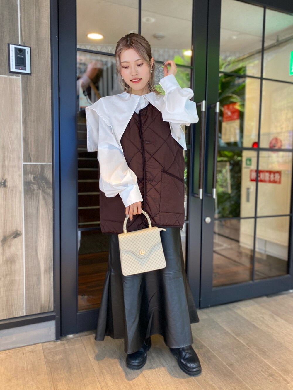 ホワイト系のシャツ/ブラウス、ブラウン系のベスト、ベージュ系のバッグを着用したレディースの冬コーディネートの3枚目の写真