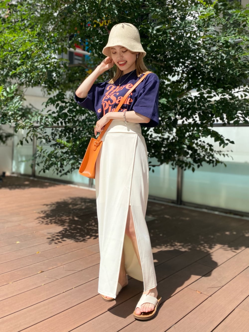 ブラック系のTシャツ/カットソー、オレンジ系のショルダーバッグ、ホワイト系のスカートを着用したレディースの夏コーディネートの2枚目の写真