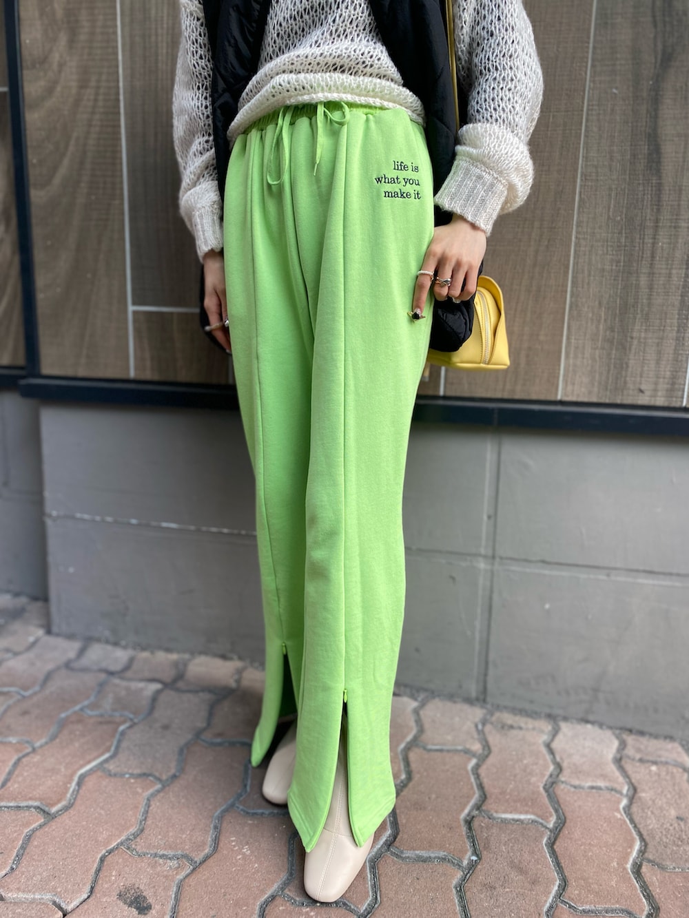 ホワイト系のカーディガン/ボレロ、イエロー系のバッグ、ブラック系のベストを着用したレディースの春コーディネートの3枚目の写真