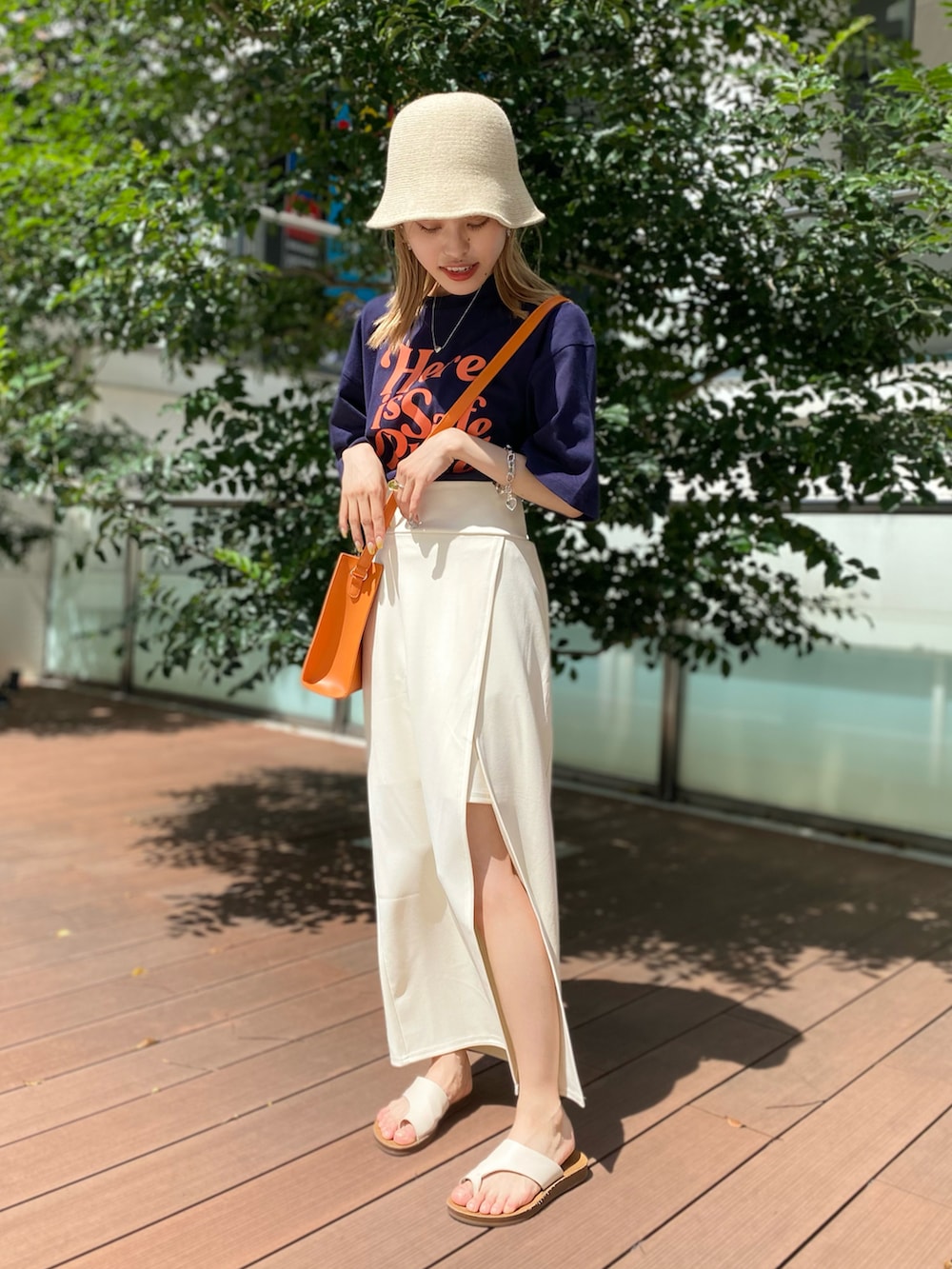 ブラック系のTシャツ/カットソー、オレンジ系のショルダーバッグ、ホワイト系のスカートを着用したレディースの夏コーディネートの4枚目の写真