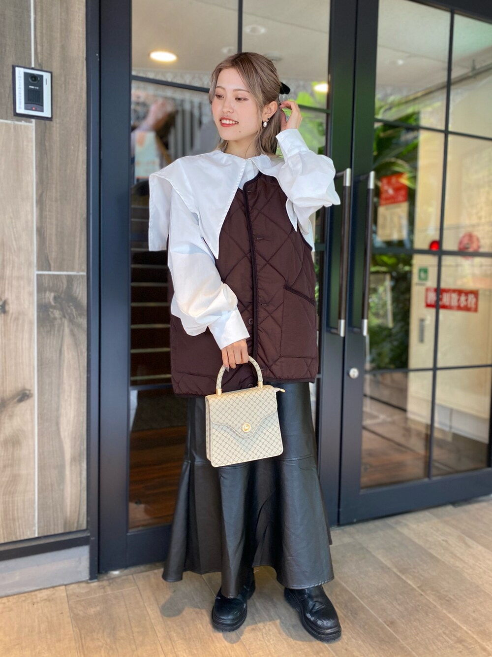 ホワイト系のシャツ/ブラウス、ブラウン系のベスト、ベージュ系のバッグを着用したレディースの冬コーディネートの2枚目の写真