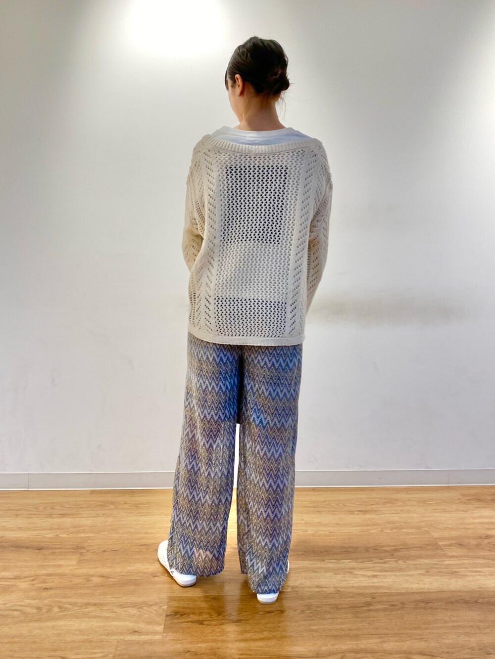 ホワイト系のニット/セーター、ブラウン系のトートバッグ、ブルー系のその他パンツを着用したレディースの春コーディネートの4枚目の写真