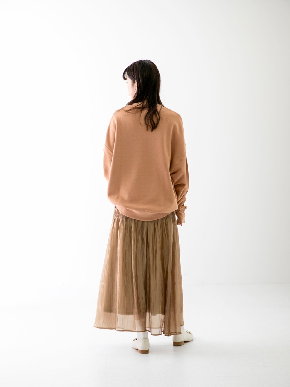 ピンク系のスウェット、ベージュ系のスカート、ホワイト系のローファーを着用したレディースの春コーディネートの3枚目の写真