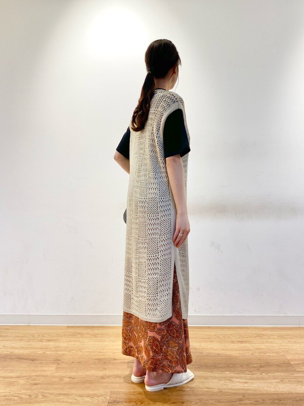 ベージュ系のベスト、ブラック系のTシャツ/カットソー、オレンジ系のスカートを着用したレディースの春コーディネートの2枚目の写真