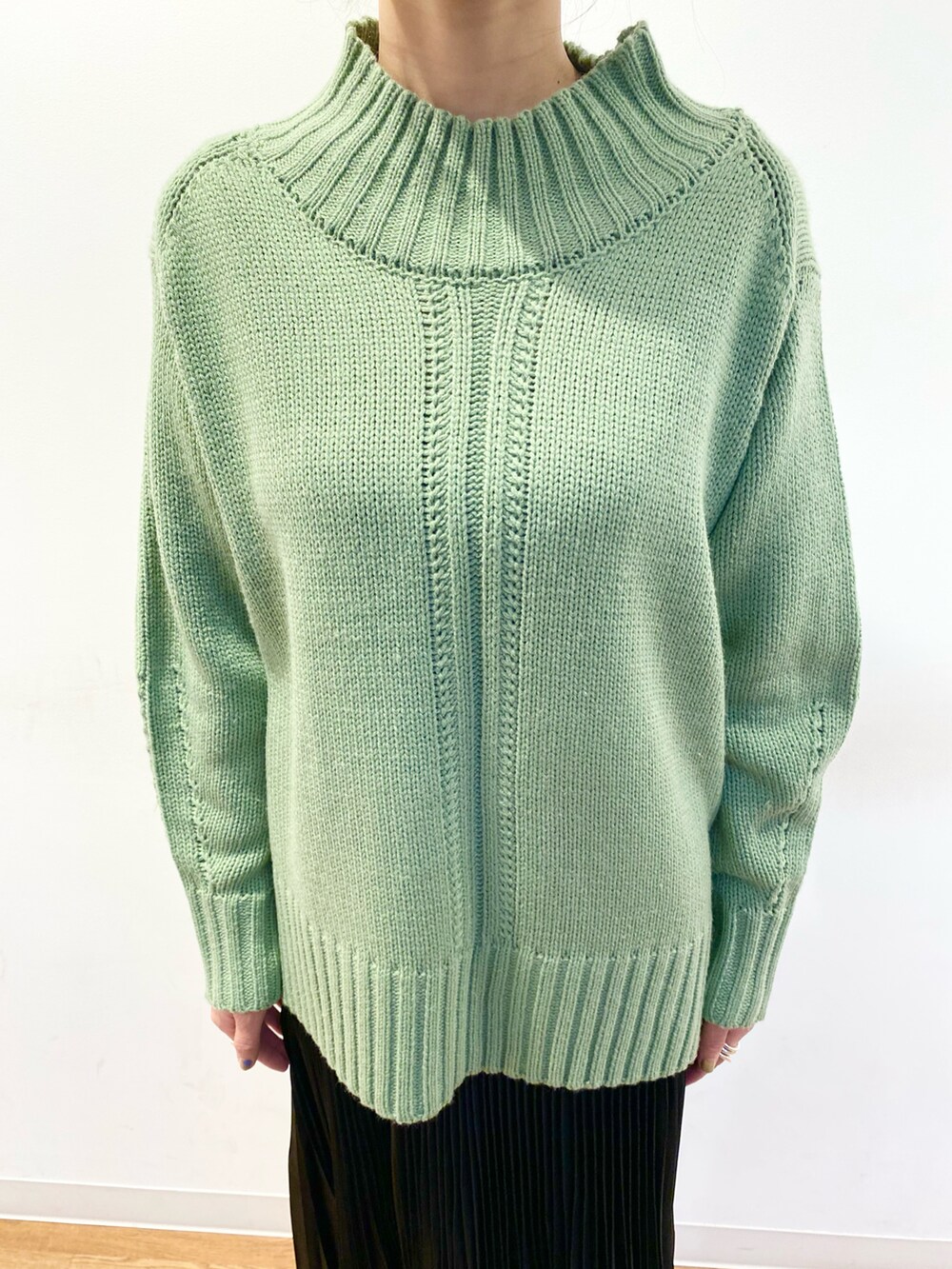 グリーン系のニット/セーター、ベージュ系のショルダーバッグ、ブラック系のスカートを着用したレディースの冬コーディネートの4枚目の写真