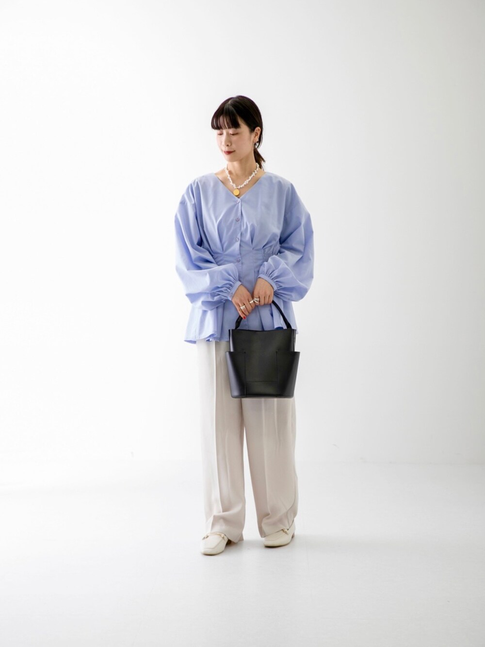 ブルー系のシャツ/ブラウス、ブラック系のトートバッグ、ベージュ系のその他パンツを着用したレディースの冬コーディネートの2枚目の写真