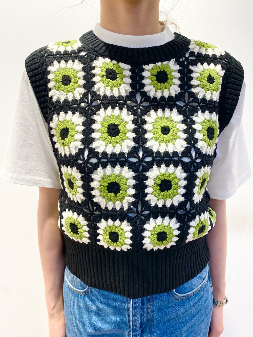 ブルー系のデニムパンツ、グリーン系のショルダーバッグ、ホワイト系のその他シューズを着用したレディースの春コーディネートの4枚目の写真