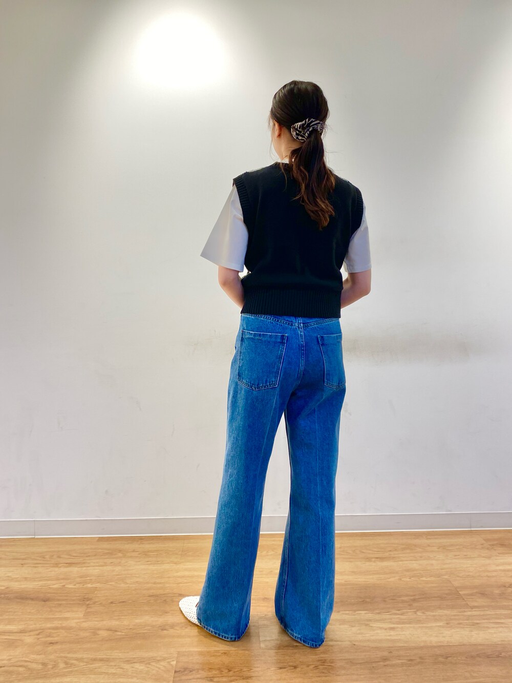ブルー系のデニムパンツ、グリーン系のショルダーバッグ、ホワイト系のその他シューズを着用したレディースの春コーディネートの3枚目の写真