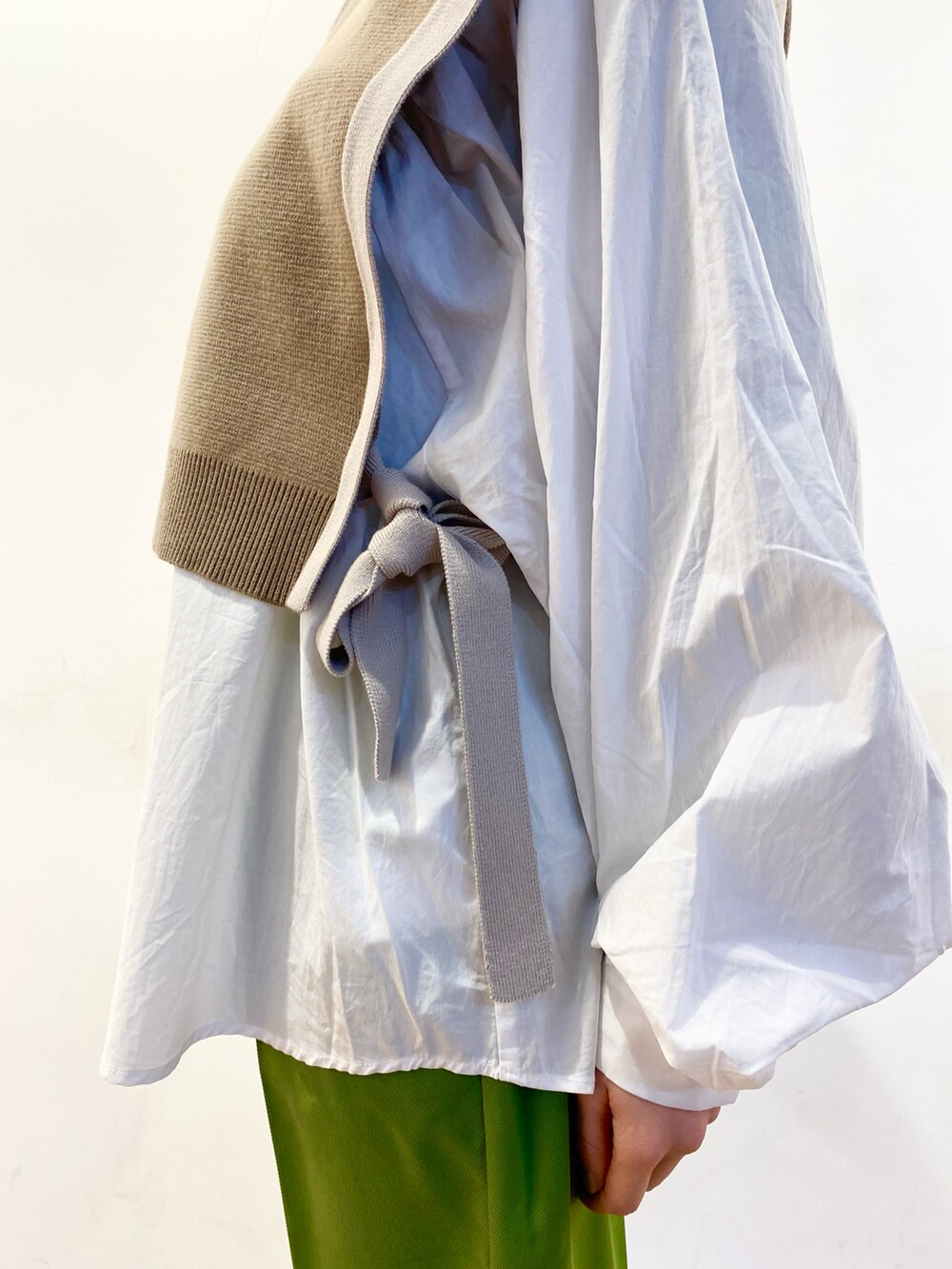 ベージュ系のベスト、ホワイト系のシャツ/ブラウス、ホワイト系のローファーを着用したレディースの冬コーディネートの4枚目の写真