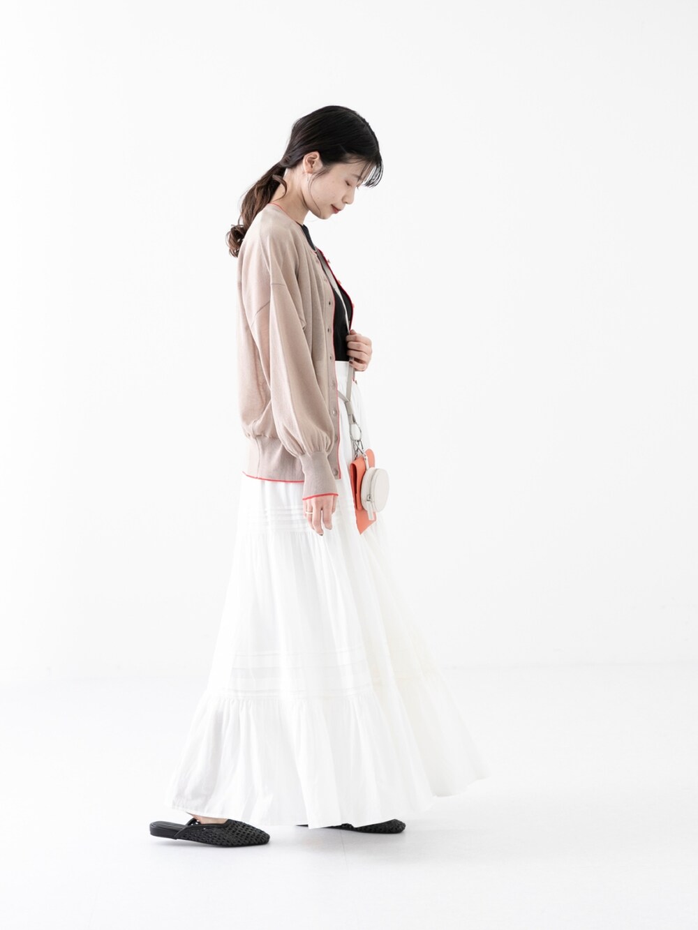 ブラック系のタンクトップ、オレンジ系のショルダーバッグ、ブラック系のその他シューズを着用したレディースの春コーディネートの2枚目の写真