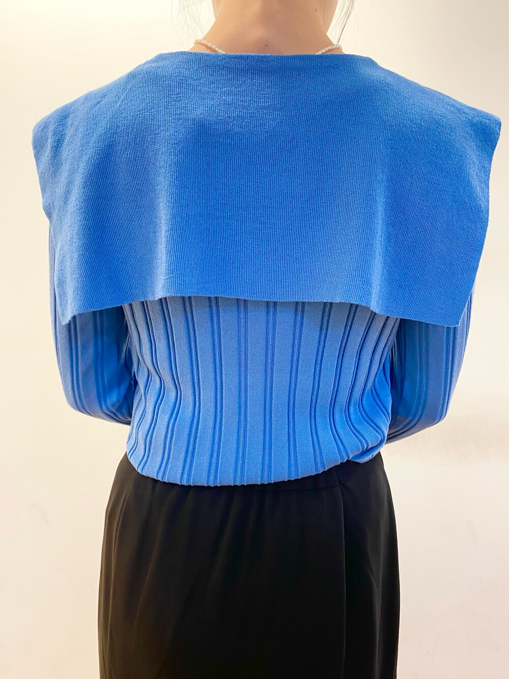 ブルー系のカーディガン/ボレロ、ブラック系のスカート、ブラック系のショルダーバッグを着用したレディースの春コーディネートの5枚目の写真