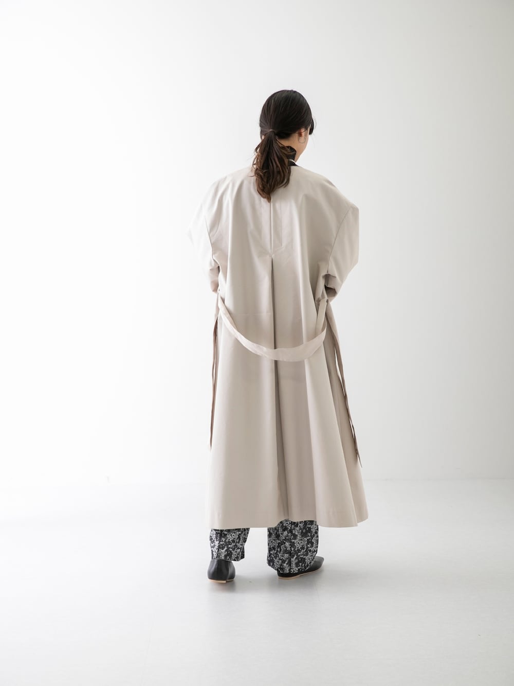 ブラック系のニット/セーター、ベージュ系のトレンチコート、ブラック系のその他パンツを着用したレディースの春コーディネートの3枚目の写真