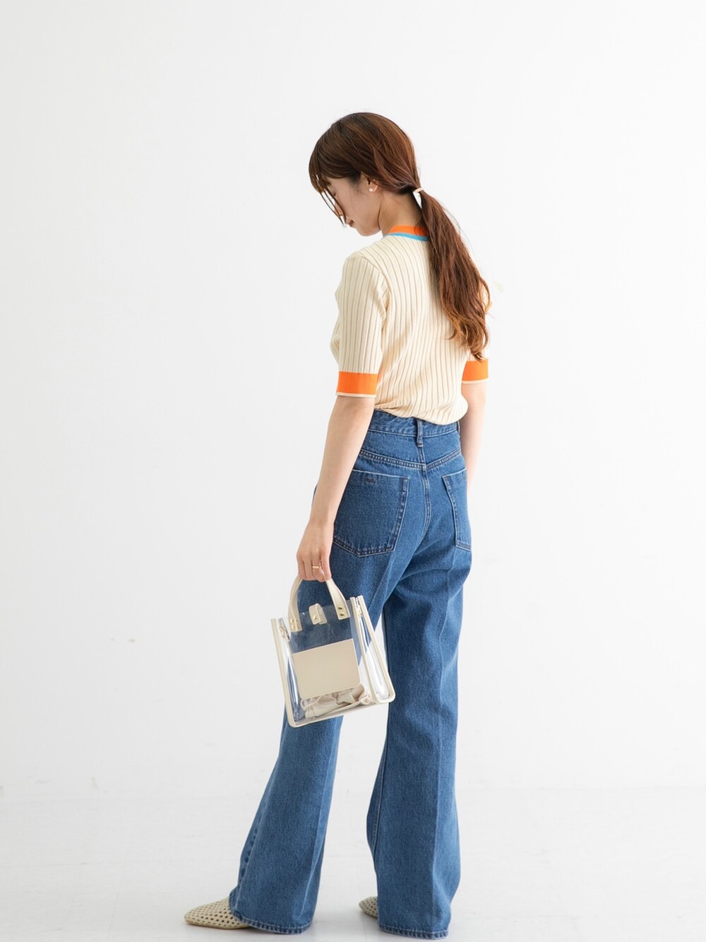 ホワイト系のニット/セーター、ブルー系のデニムパンツ、ホワイト系のショルダーバッグを着用したレディースの夏コーディネートの5枚目の写真