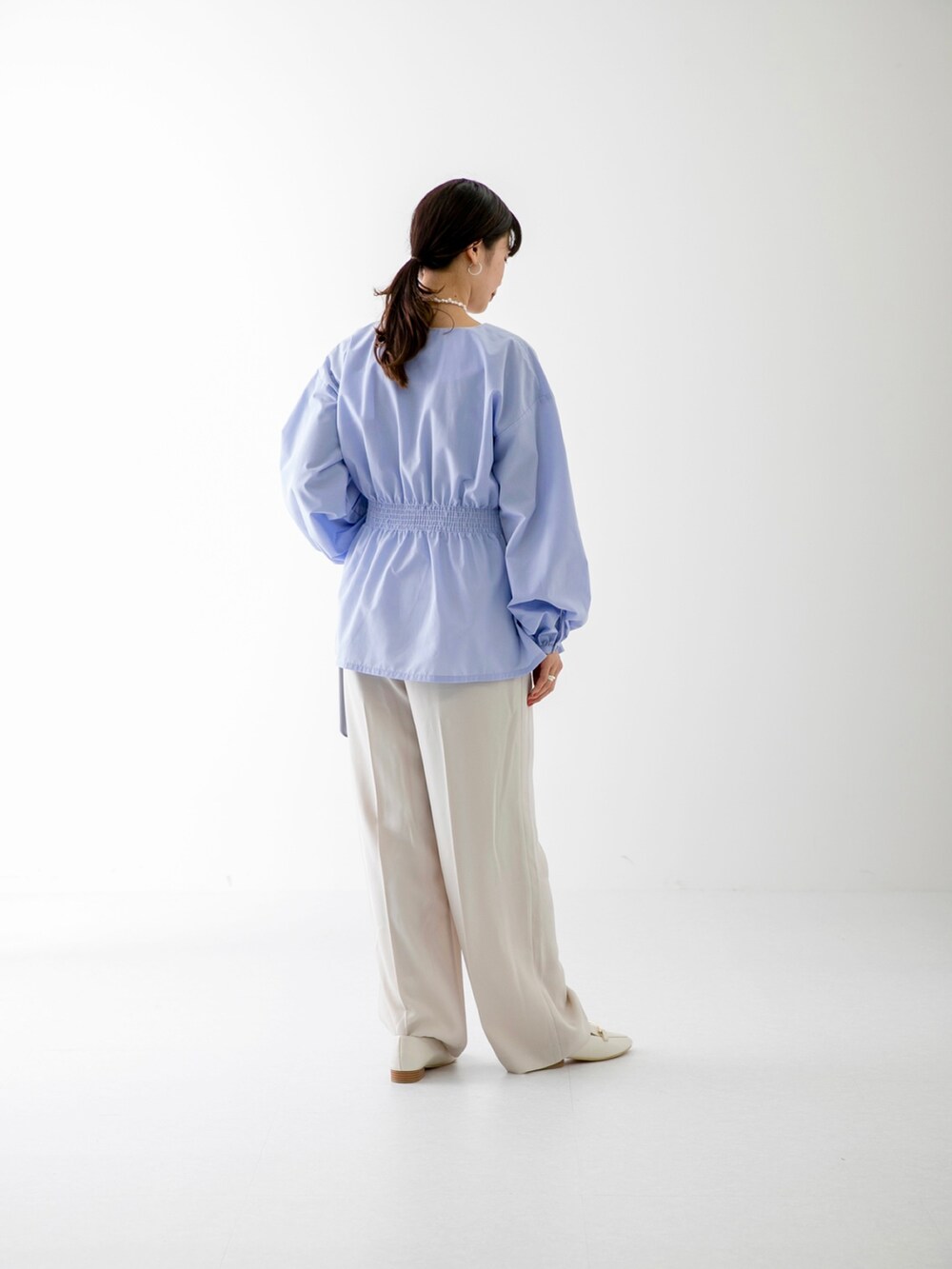 ブルー系のシャツ/ブラウス、ブラック系のトートバッグ、ベージュ系のその他パンツを着用したレディースの冬コーディネートの3枚目の写真