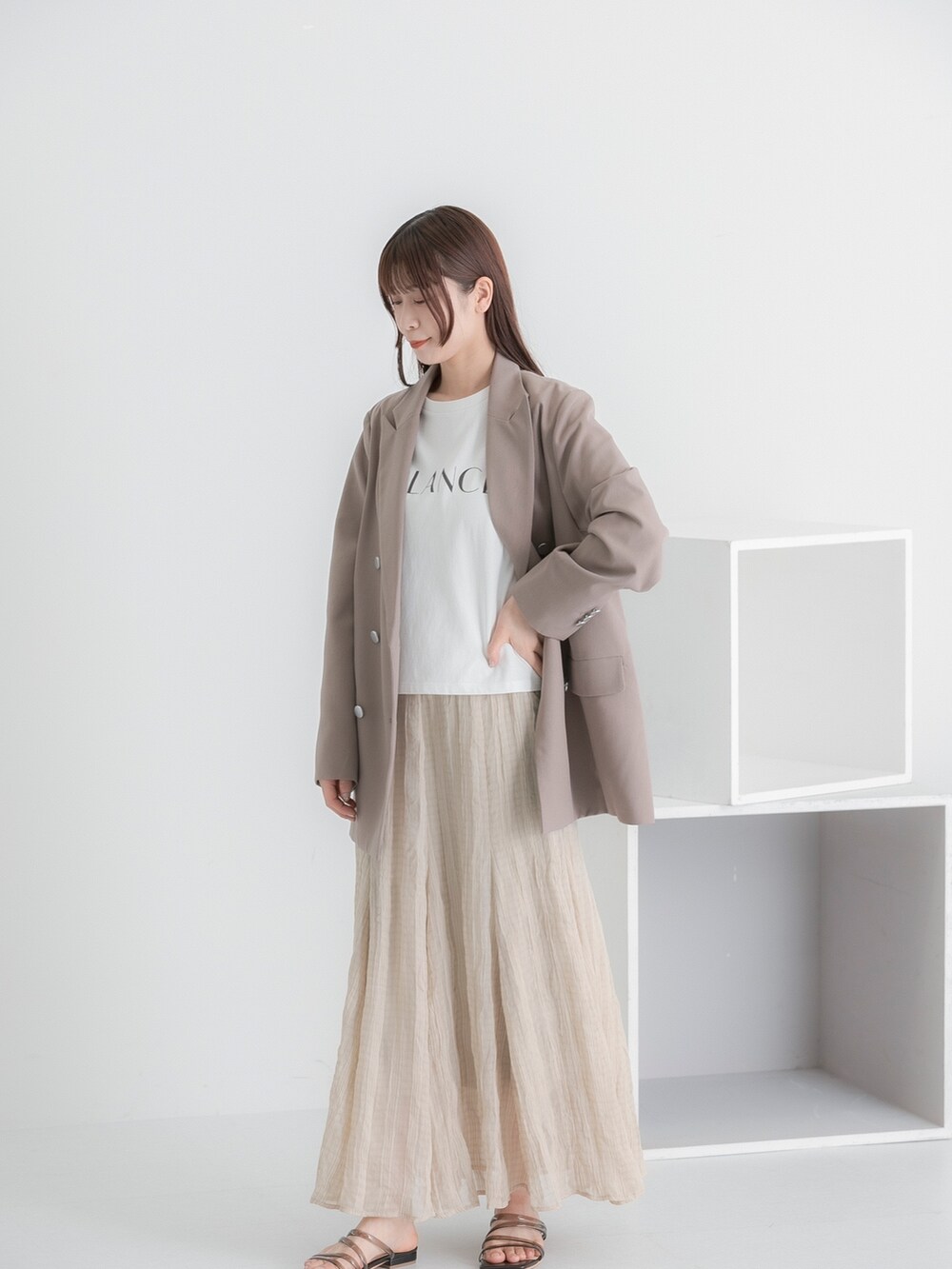 その他のTシャツ/カットソー、ブラウン系のテーラードジャケット、ベージュ系のスカートを着用したレディースの春コーディネートの3枚目の写真