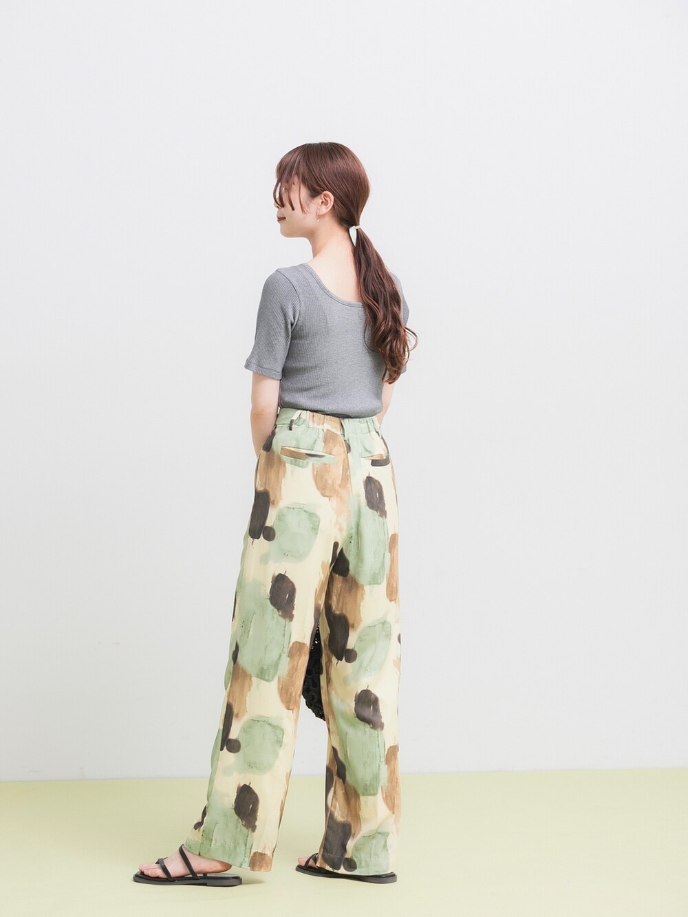 ブラック系のTシャツ/カットソー、イエロー系のその他パンツ、ブラック系のかごバッグを着用したレディースの春コーディネートの4枚目の写真