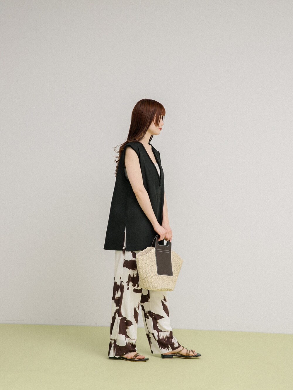 ブラック系のベスト、ホワイト系のトートバッグ、ブラック系のサンダルを着用したレディースの春コーディネートの3枚目の写真
