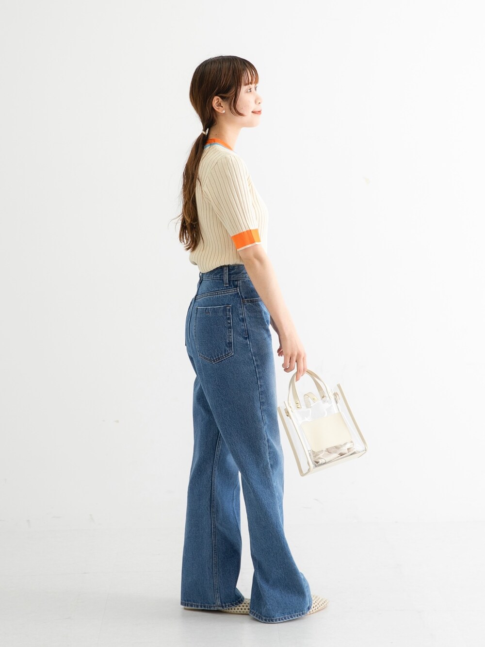 ホワイト系のニット/セーター、ブルー系のデニムパンツ、ホワイト系のショルダーバッグを着用したレディースの夏コーディネートの3枚目の写真