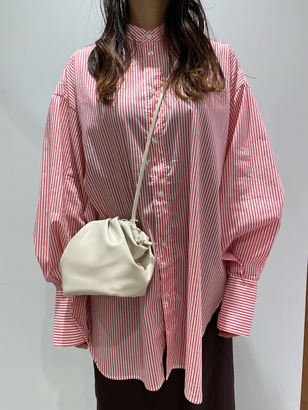 ホワイト系のショルダーバッグ、ピンク系のシャツ/ブラウス、ブラウン系のスカートを着用したレディースの夏コーディネートの2枚目の写真