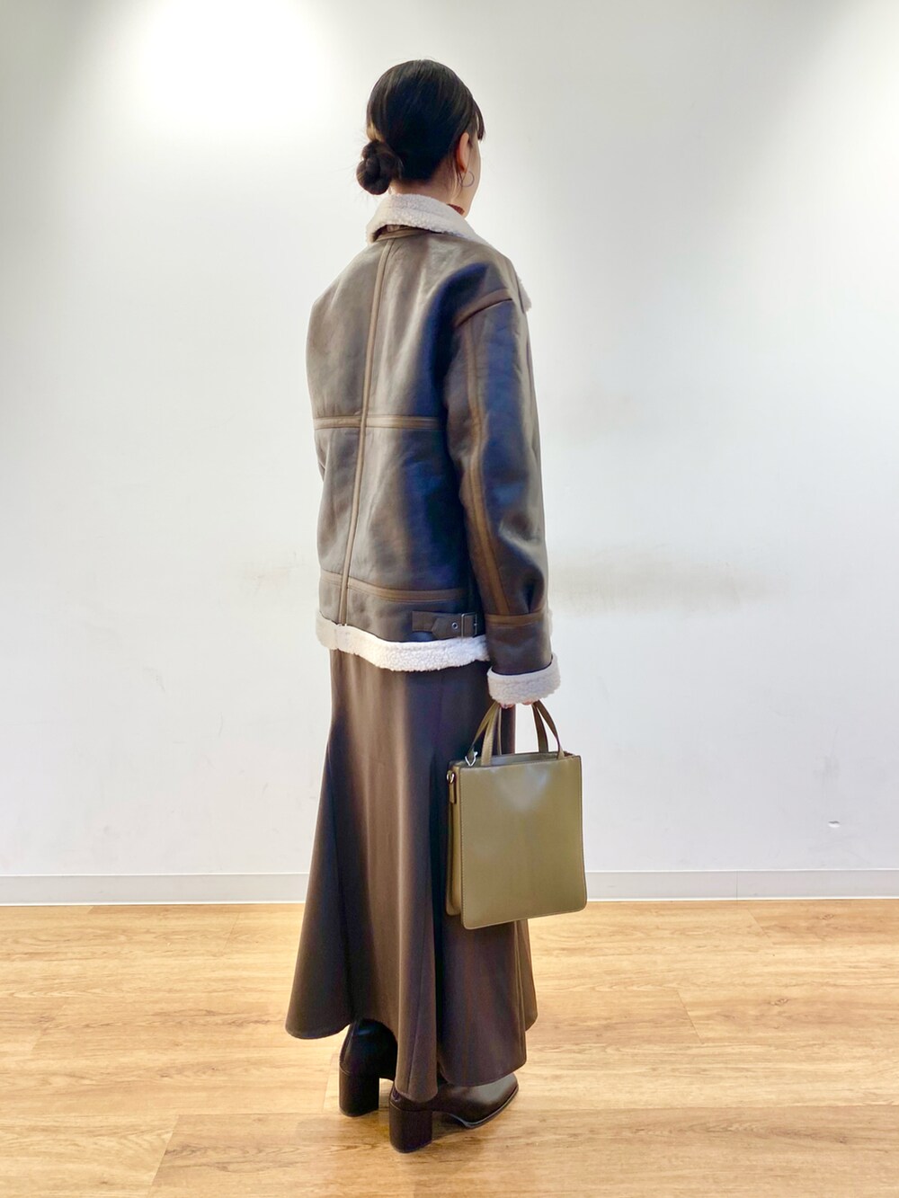 ブラウン系のスカート、ブラウン系のブルゾン、ブラウン系のブーツを着用したレディースの冬コーディネートの2枚目の写真