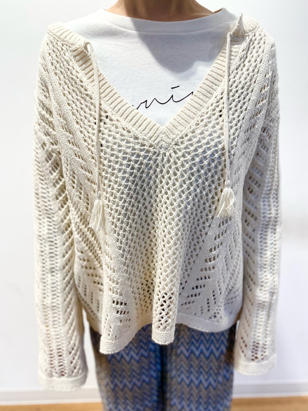 ホワイト系のニット/セーター、ブラウン系のトートバッグ、ブルー系のその他パンツを着用したレディースの春コーディネートの5枚目の写真