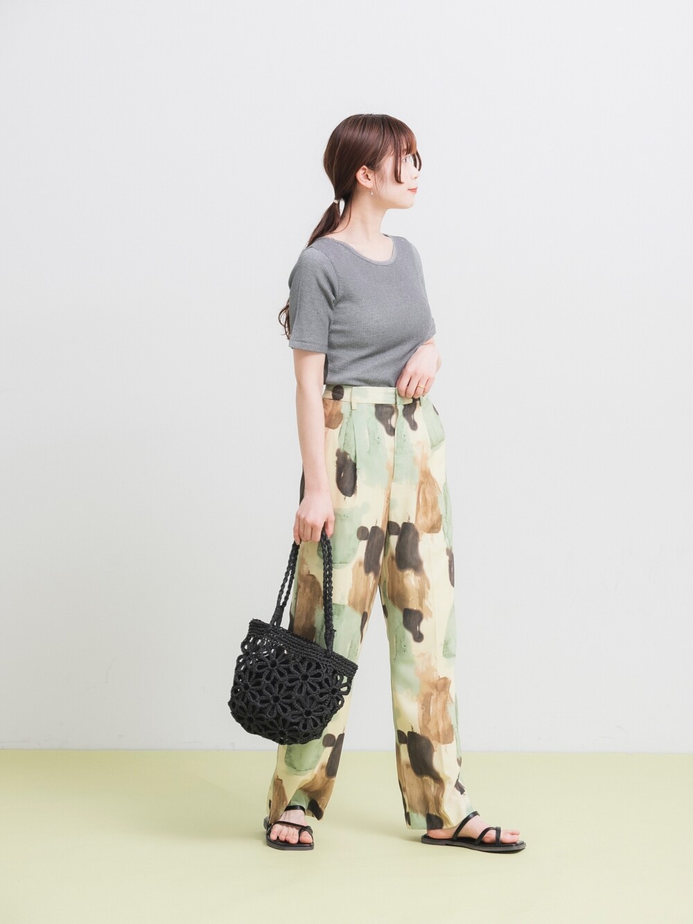 ブラック系のTシャツ/カットソー、イエロー系のその他パンツ、ブラック系のかごバッグを着用したレディースの春コーディネートの2枚目の写真