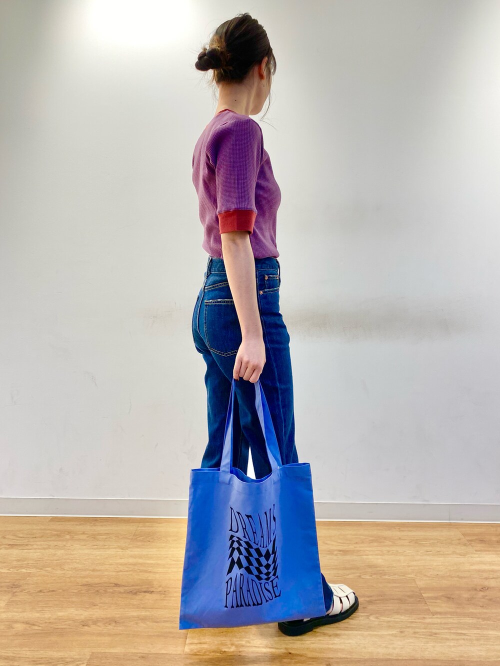 ホワイト系のサンダル、パープル系のTシャツ/カットソー、ブルー系のデニムパンツを着用したレディースの春コーディネートの2枚目の写真