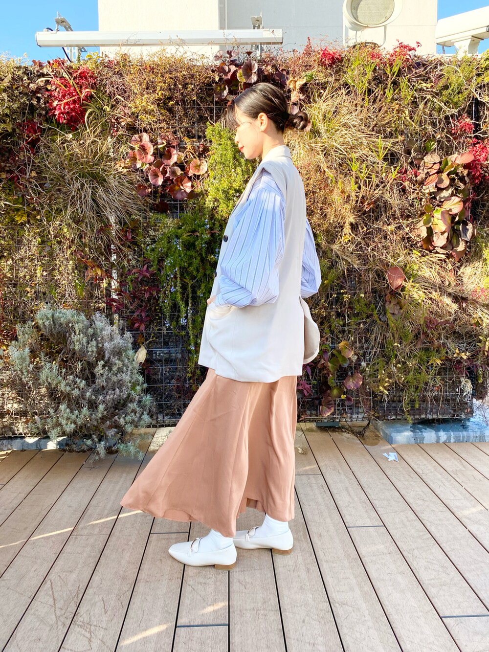 ホワイト系のシャツ/ブラウス、ベージュ系のベスト、ピンク系のスカートを着用したレディースの春コーディネートの2枚目の写真