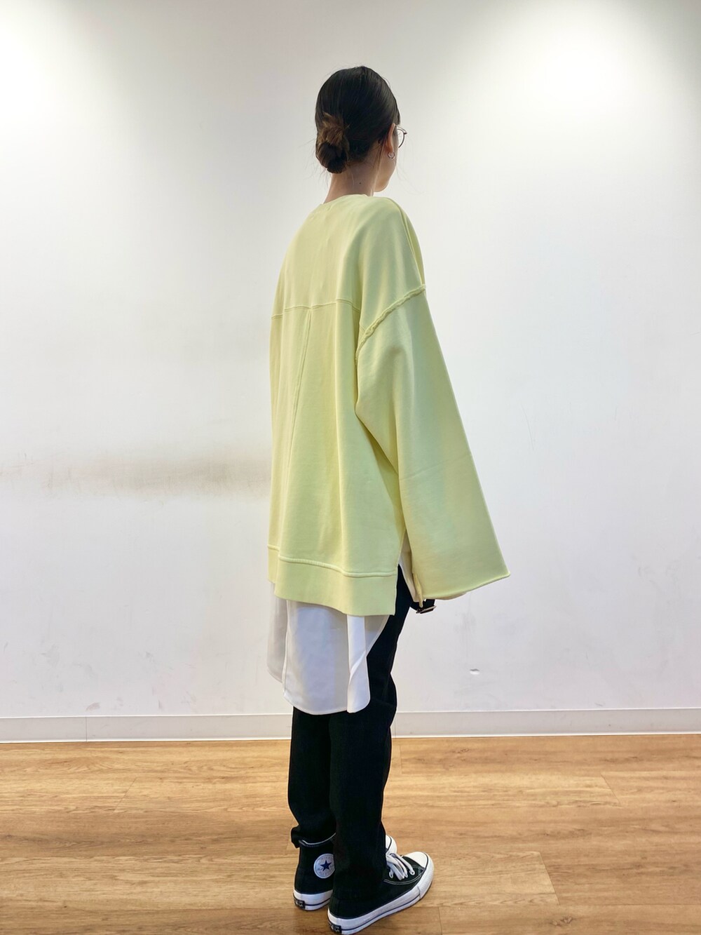 イエロー系のスウェット、ブラック系のトートバッグ、ホワイト系のシャツ/ブラウスを着用したレディースの冬コーディネートの5枚目の写真