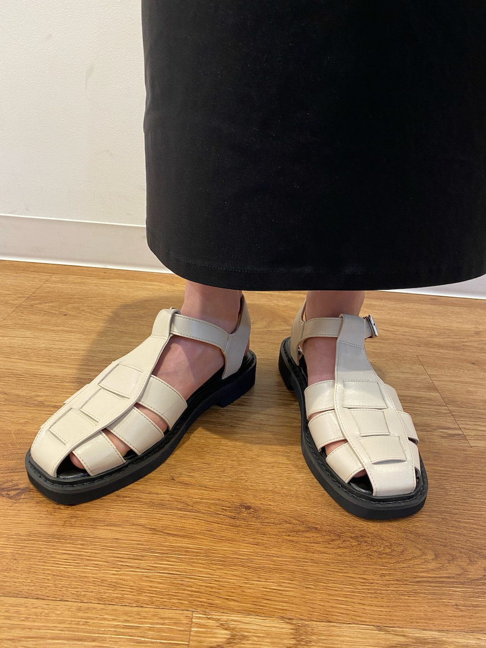 ブラック系のスカート、ホワイト系のシャツ/ブラウス、ブラック系のタンクトップを着用したレディースの夏コーディネートの3枚目の写真