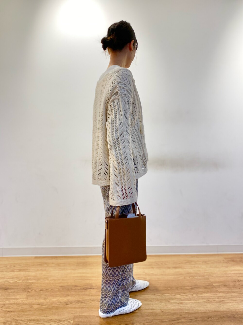 ホワイト系のニット/セーター、ブラウン系のトートバッグ、ブルー系のその他パンツを着用したレディースの春コーディネートの3枚目の写真