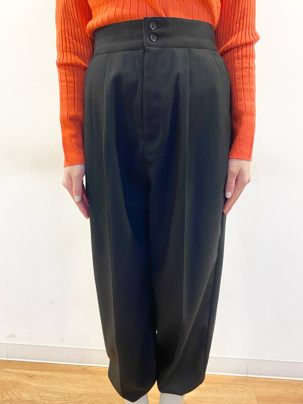 レッド系のニット/セーター、ブラック系のボディバッグ/ウエストポーチ、ホワイト系のブーツを着用したレディースの冬コーディネートの3枚目の写真