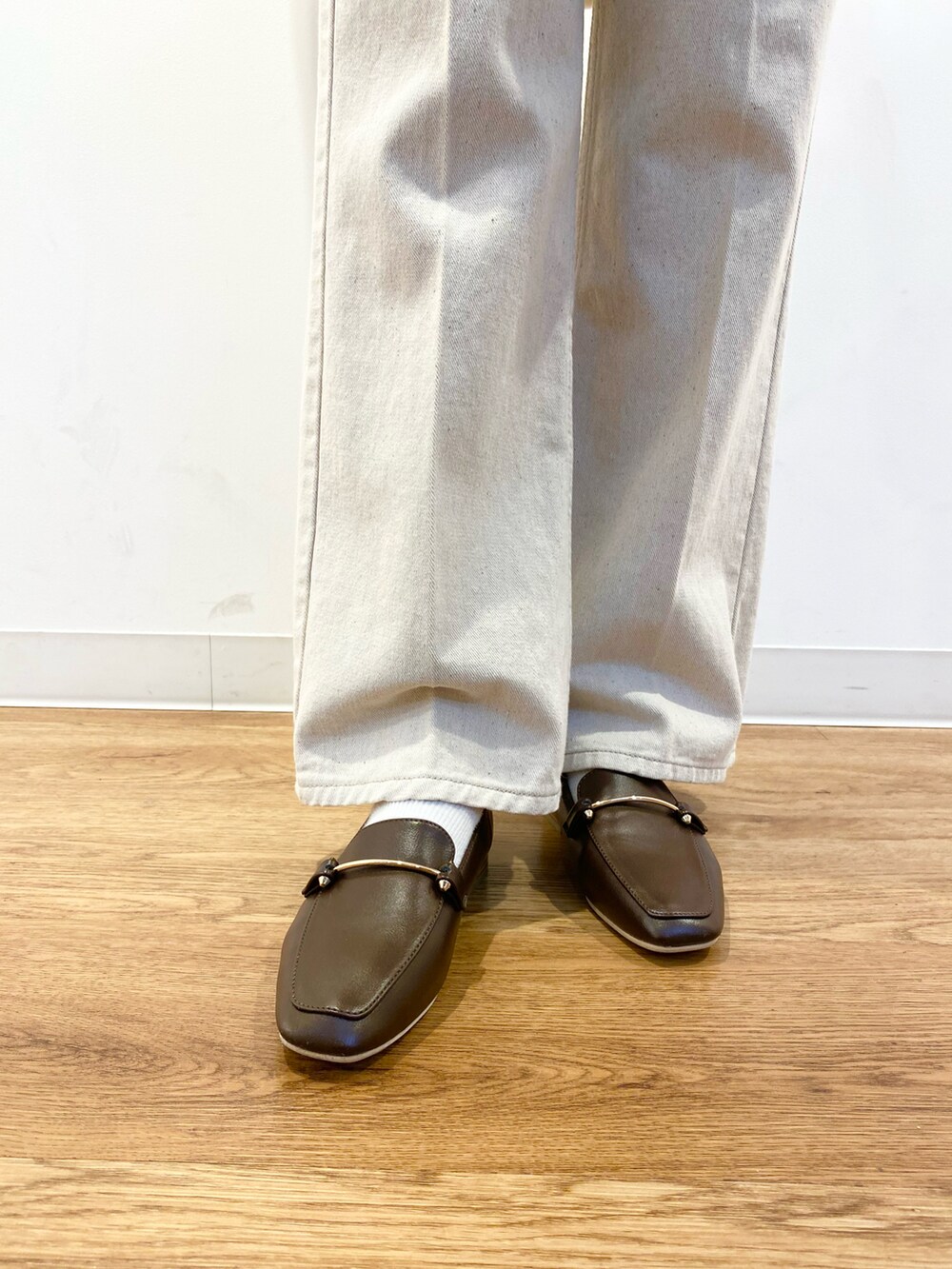 レッド系のニット/セーター、ホワイト系のシャツ/ブラウス、ブラウン系のショルダーバッグを着用したレディースの冬コーディネートの5枚目の写真