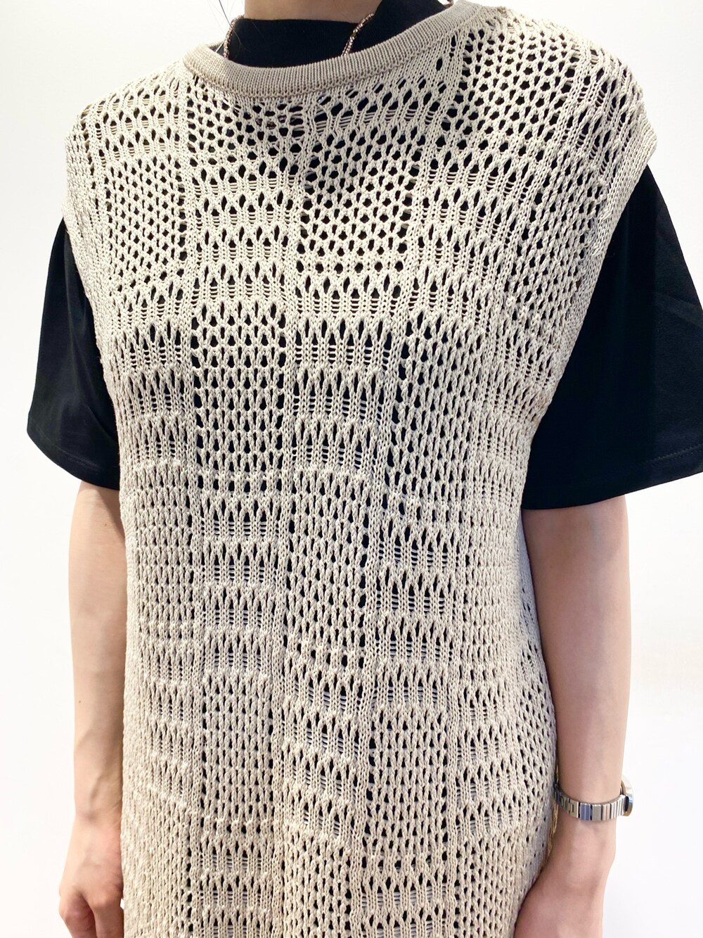 ベージュ系のベスト、ブラック系のTシャツ/カットソー、オレンジ系のスカートを着用したレディースの春コーディネートの3枚目の写真