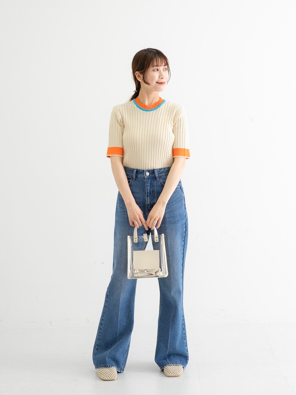 ホワイト系のニット/セーター、ブルー系のデニムパンツ、ホワイト系のショルダーバッグを着用したレディースの夏コーディネートの2枚目の写真