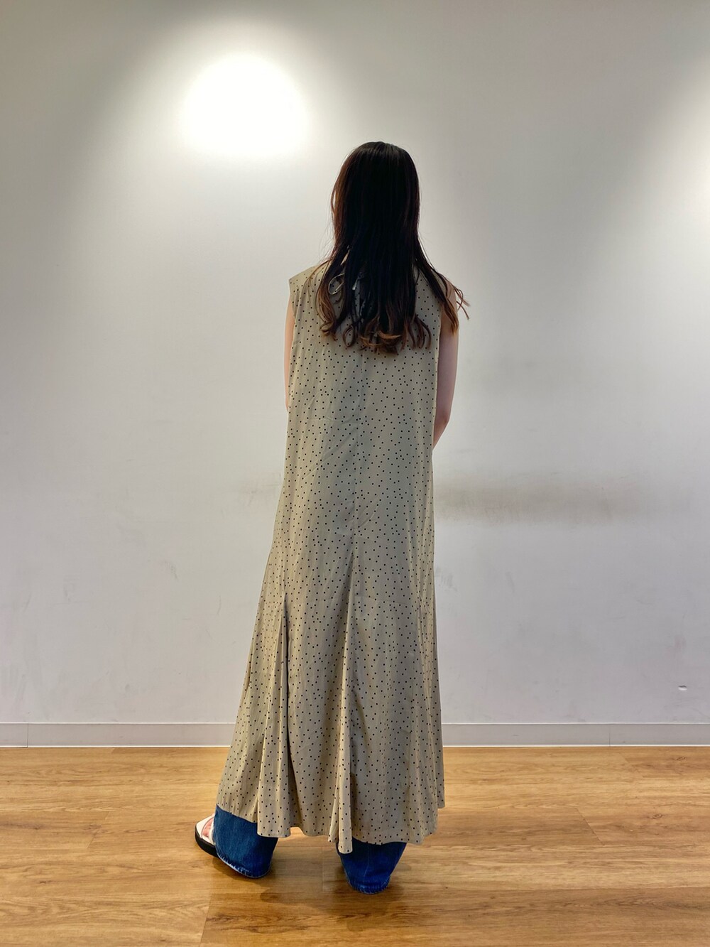 ベージュ系のワンピース、ブルー系のデニムパンツ、グリーン系のハンドバッグを着用したレディースの夏コーディネートの3枚目の写真