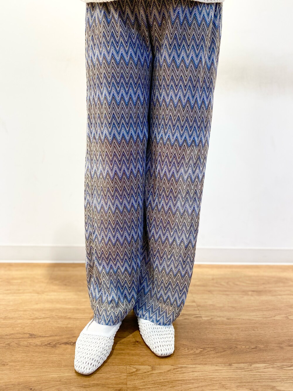 ホワイト系のニット/セーター、ブラウン系のトートバッグ、ブルー系のその他パンツを着用したレディースの春コーディネートの2枚目の写真