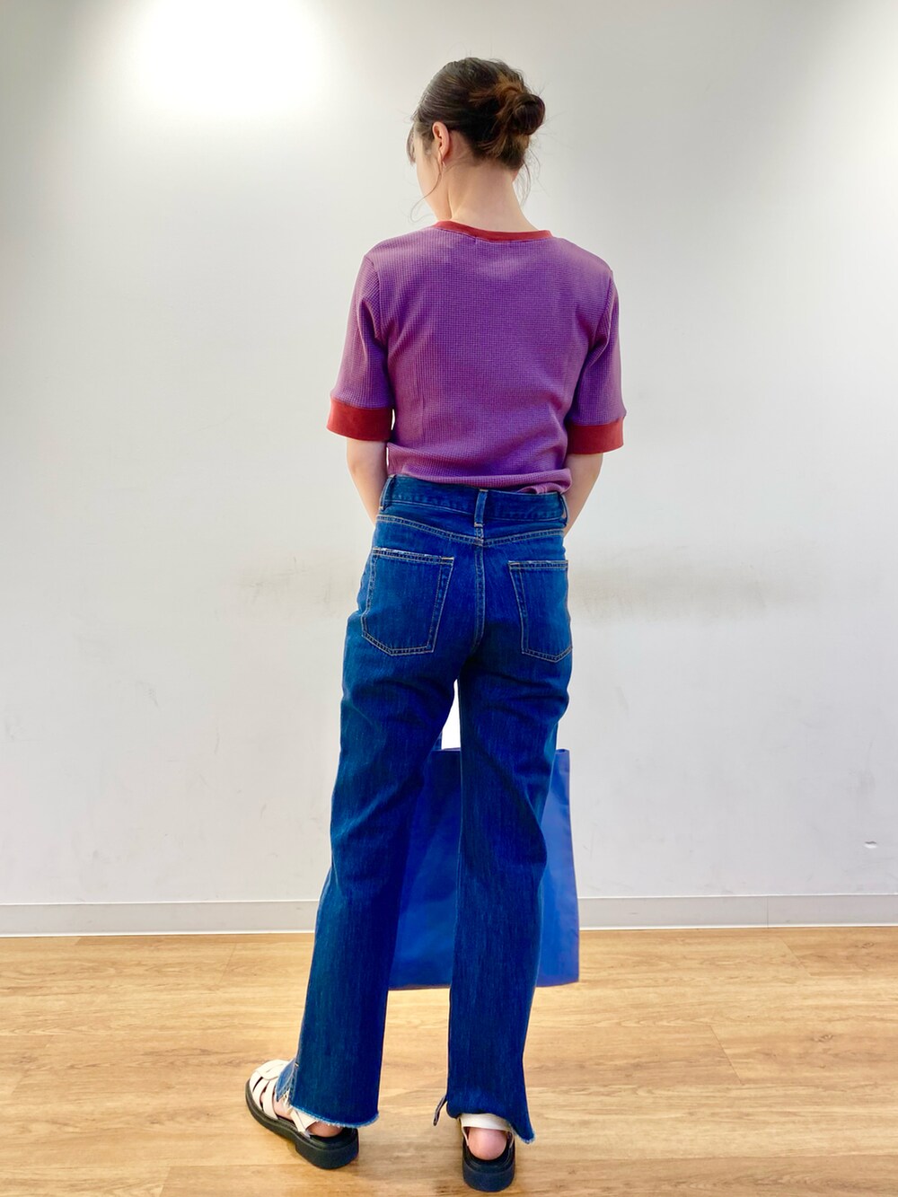 ホワイト系のサンダル、パープル系のTシャツ/カットソー、ブルー系のデニムパンツを着用したレディースの春コーディネートの3枚目の写真