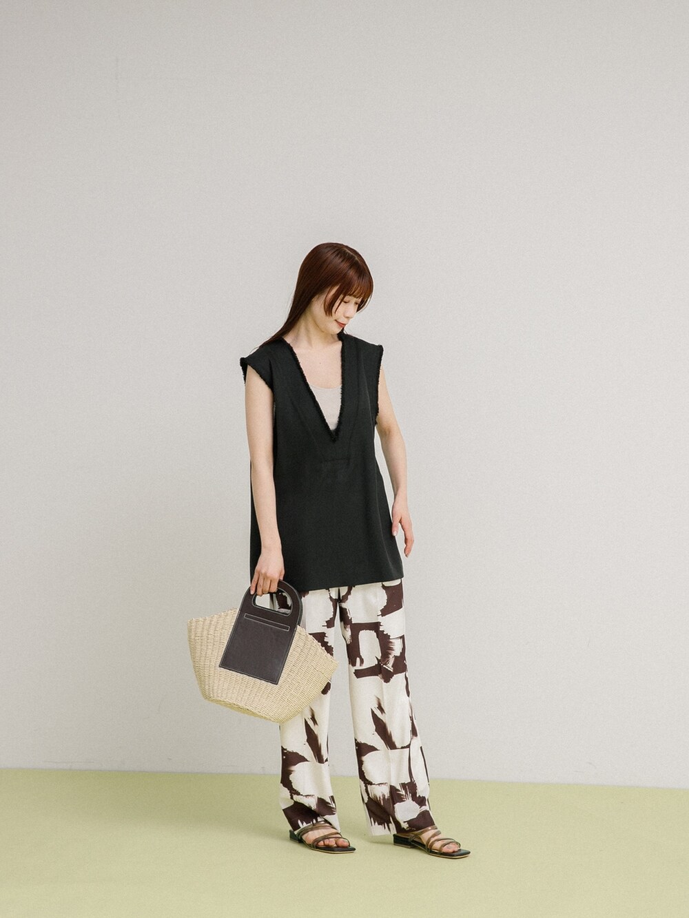 ブラック系のベスト、ホワイト系のトートバッグ、ブラック系のサンダルを着用したレディースの春コーディネートの2枚目の写真