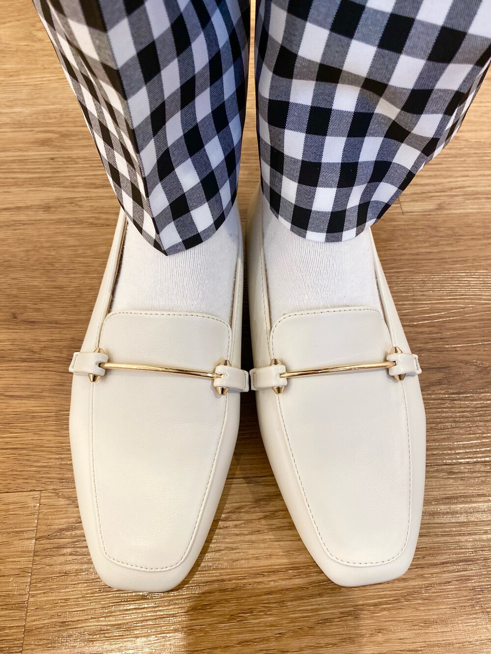 グリーン系のシャツ/ブラウス、ホワイト系のローファー、ブラック系のトートバッグを着用したレディースの春コーディネートの5枚目の写真