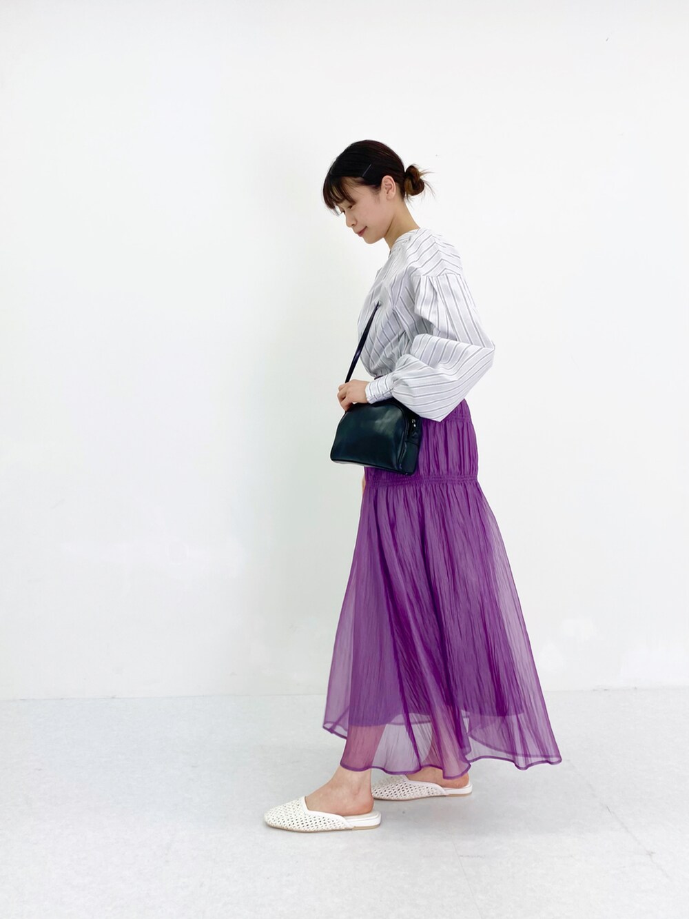 ホワイト系のシャツ/ブラウス、パープル系のスカート、ブラック系のショルダーバッグを着用したレディースの春コーディネートの2枚目の写真