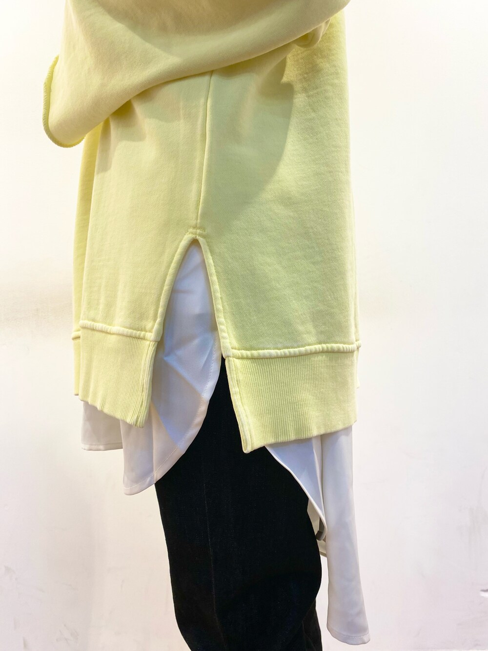 イエロー系のスウェット、ブラック系のトートバッグ、ホワイト系のシャツ/ブラウスを着用したレディースの冬コーディネートの4枚目の写真