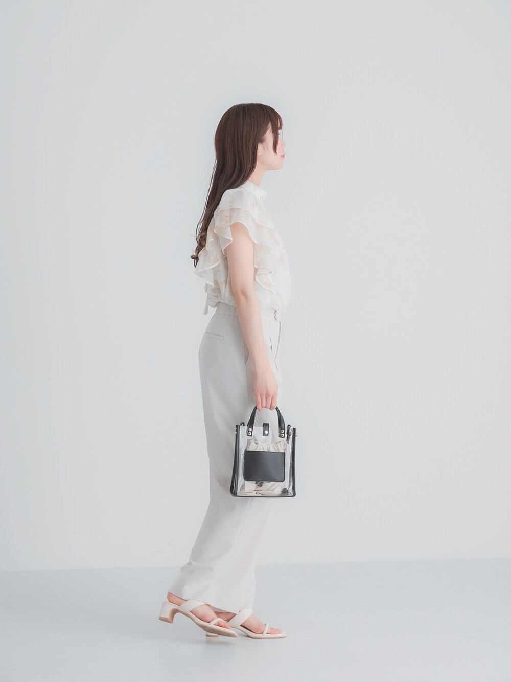 ホワイト系のシャツ/ブラウス、ブラック系のショルダーバッグ、ホワイト系のサンダルを着用したレディースの春コーディネートの3枚目の写真