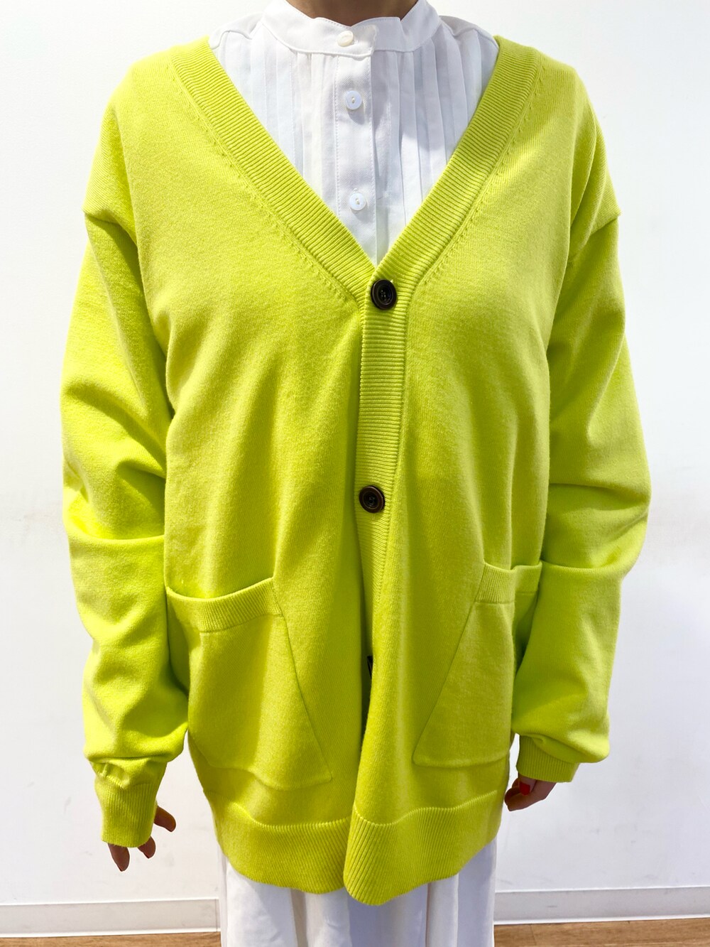 イエロー系のカーディガン/ボレロ、ホワイト系のブーツ、グリーン系のバッグを着用したレディースの冬コーディネートの3枚目の写真