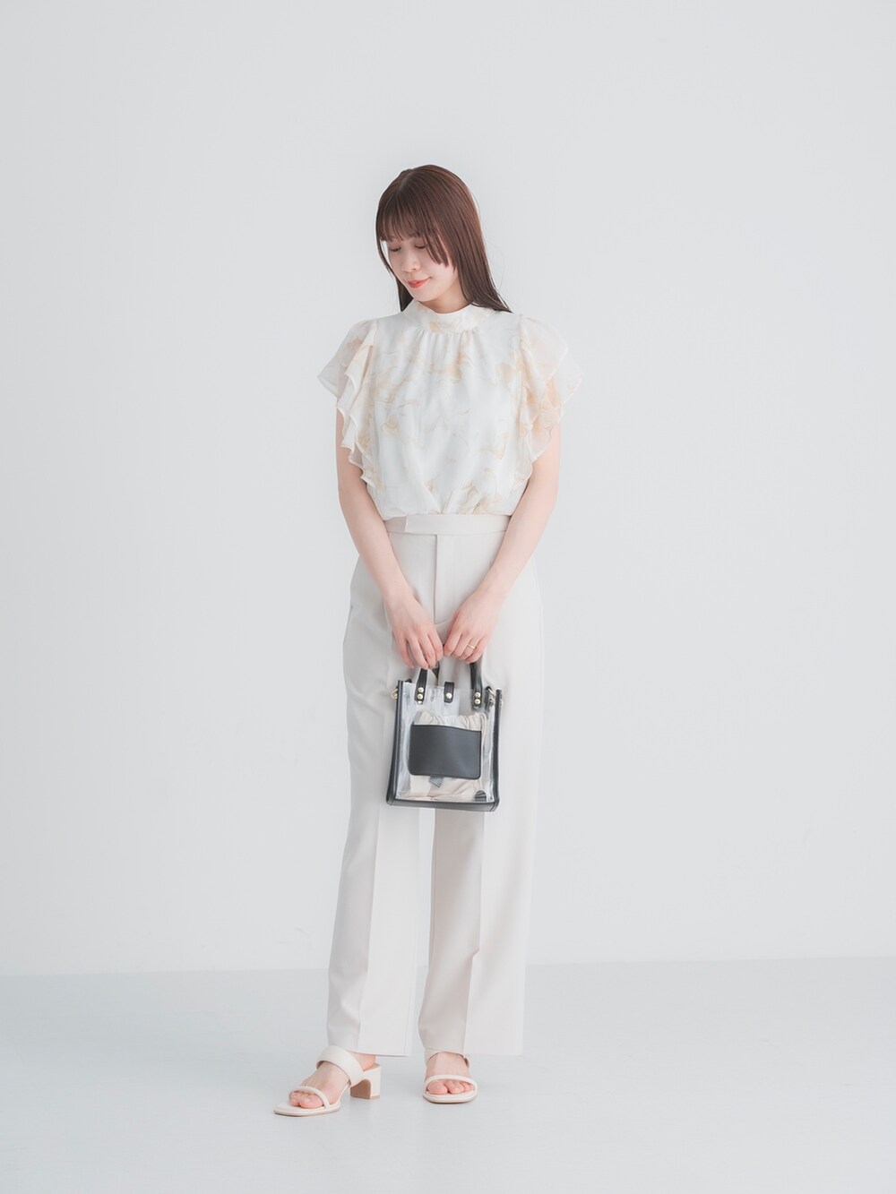 ホワイト系のシャツ/ブラウス、ブラック系のショルダーバッグ、ホワイト系のサンダルを着用したレディースの春コーディネートの2枚目の写真