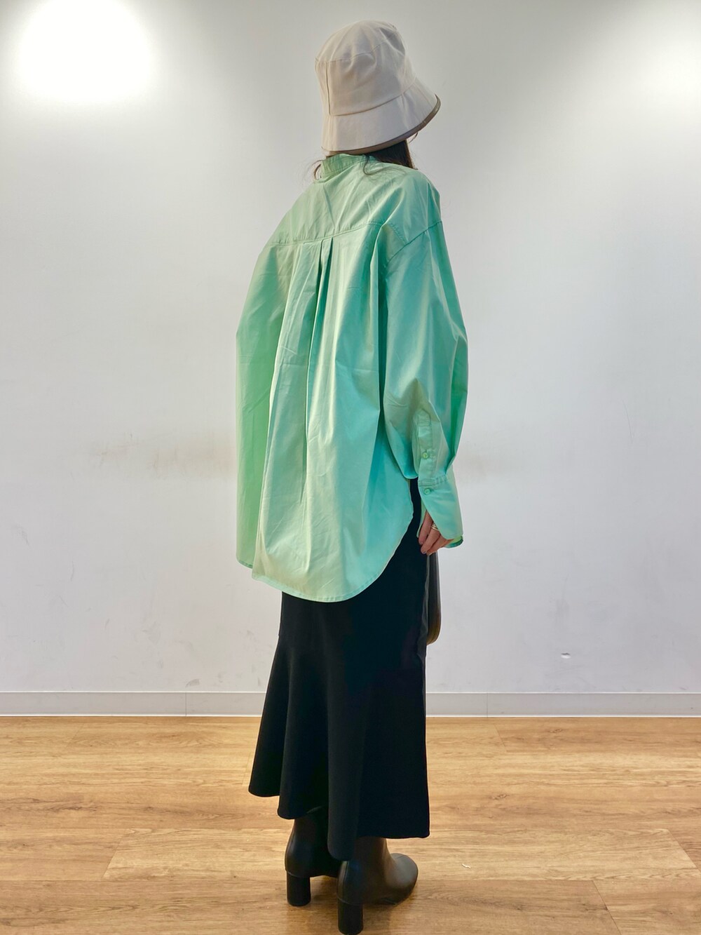 グリーン系のシャツ/ブラウス、ブラック系のスカート、ブラック系のショルダーバッグを着用したレディースの冬コーディネートの2枚目の写真