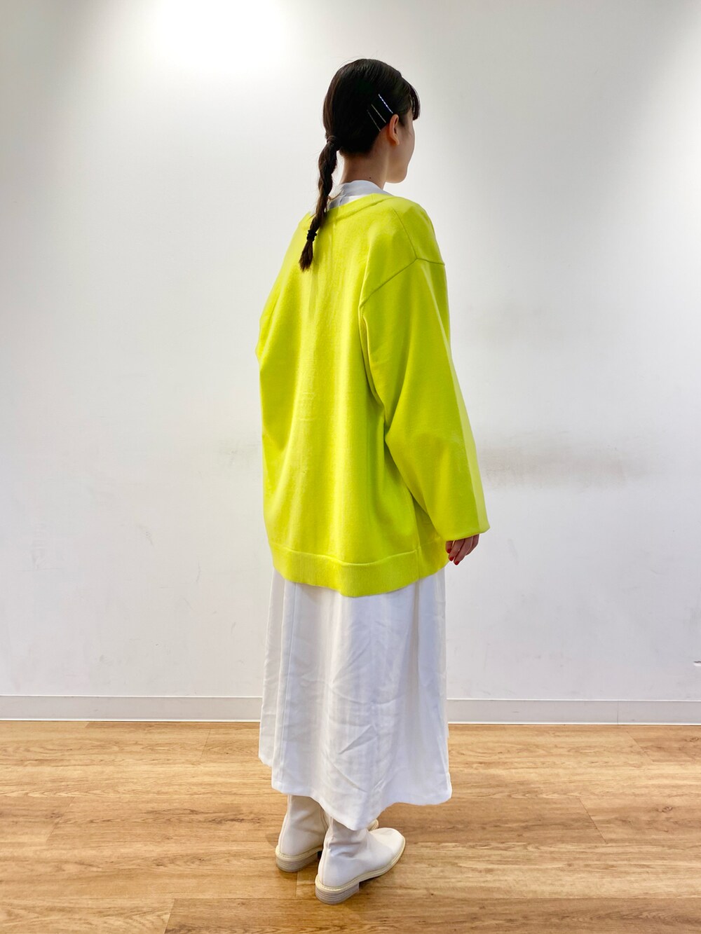 イエロー系のカーディガン/ボレロ、ホワイト系のブーツ、グリーン系のバッグを着用したレディースの冬コーディネートの2枚目の写真