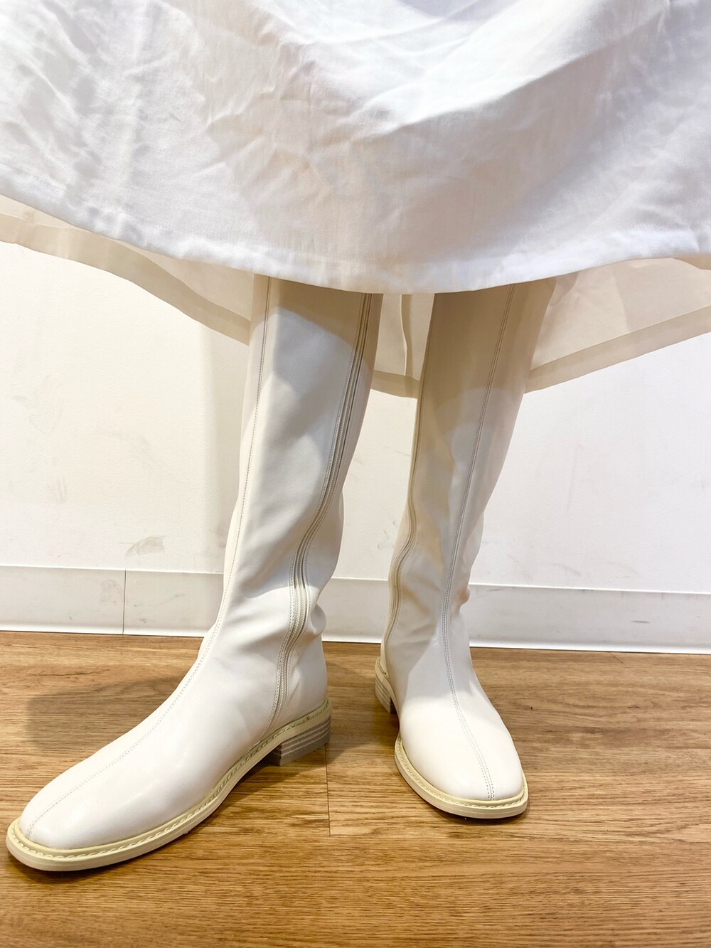 イエロー系のカーディガン/ボレロ、ホワイト系のブーツ、グリーン系のバッグを着用したレディースの冬コーディネートの5枚目の写真