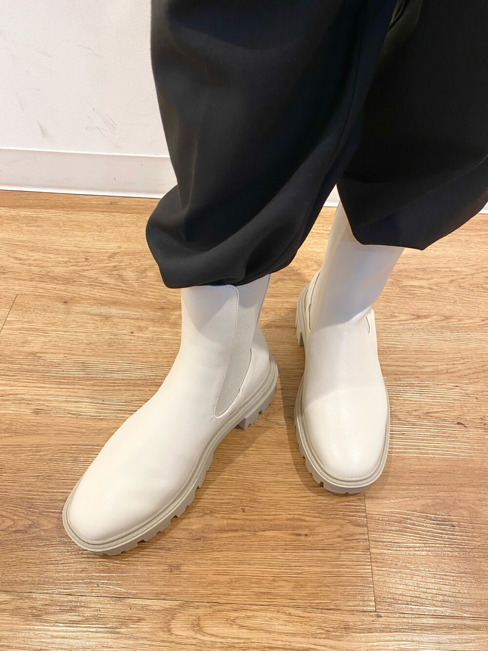 レッド系のニット/セーター、ブラック系のボディバッグ/ウエストポーチ、ホワイト系のブーツを着用したレディースの冬コーディネートの4枚目の写真